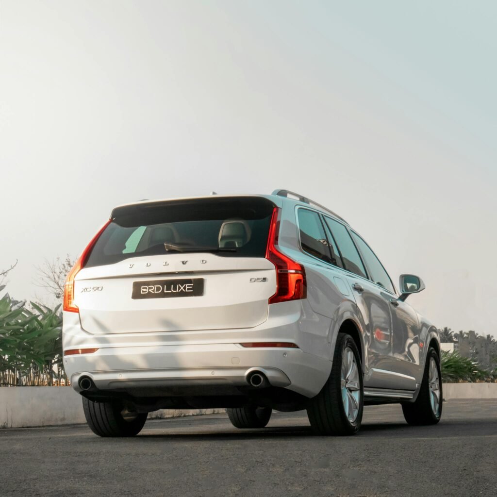 Back view of a luxury white Volvo SUV on the road, perfect for travel themes.
