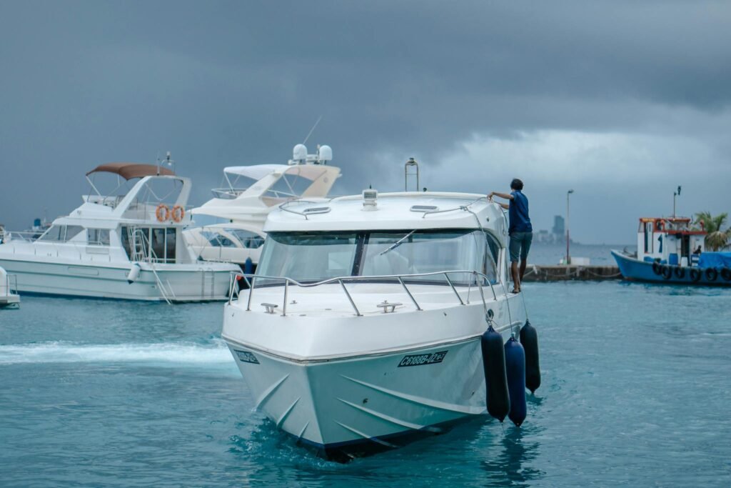White luxury yacht in a serene ocean marina with storm clouds brewing.